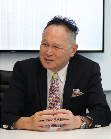 Cecil Chao seated at a boardroom table, speaking
